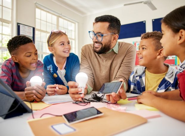 Happy,Male,Teacher,With,Solar,Panel,Explaining,Pupil,About,Solar